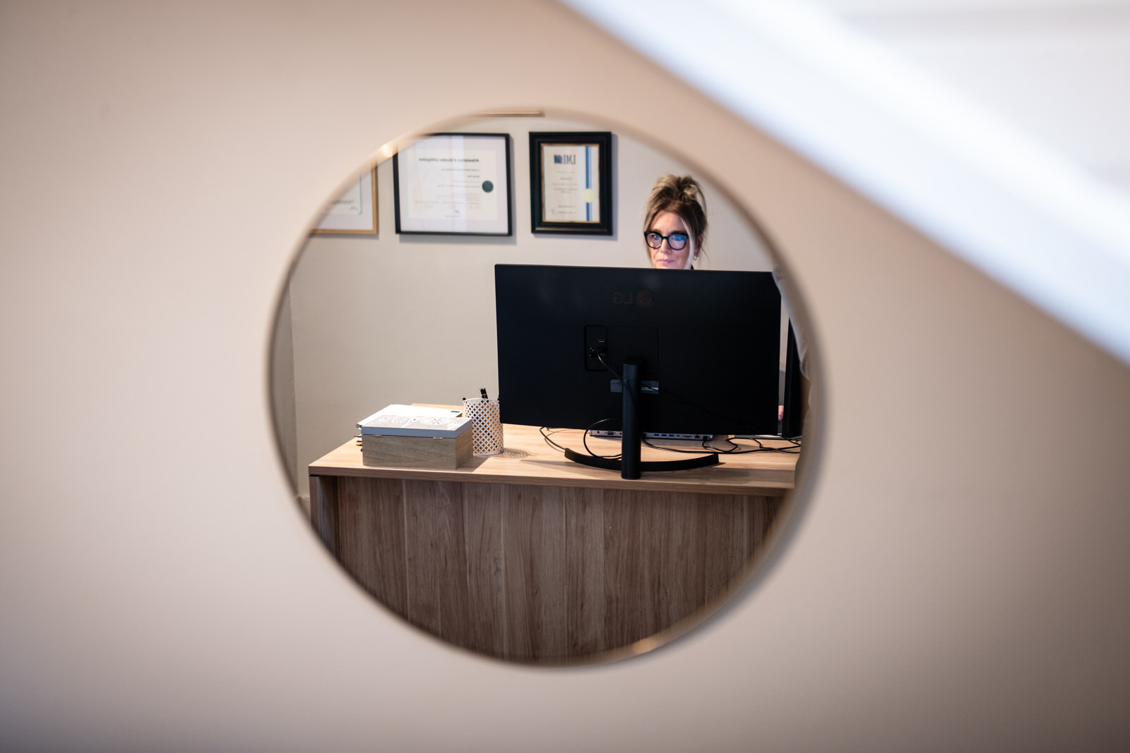 Photo reflet d'un miroir avec une femme travaillant derrière un écan