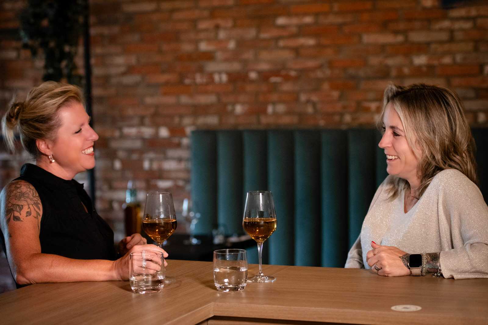 Photo de deux femmes discutant à un comptoir avec coupe de vin