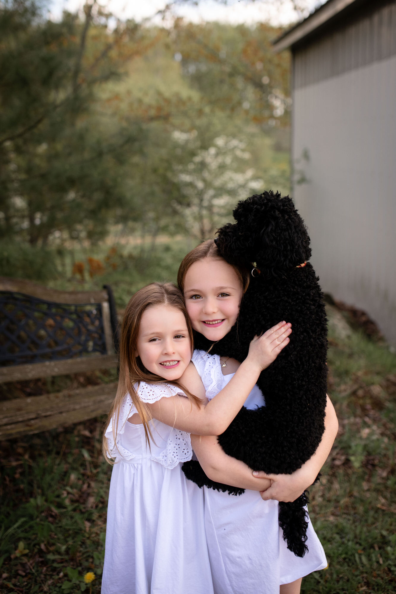 Photo portrait de deux jeunes filles avec leur chien noir