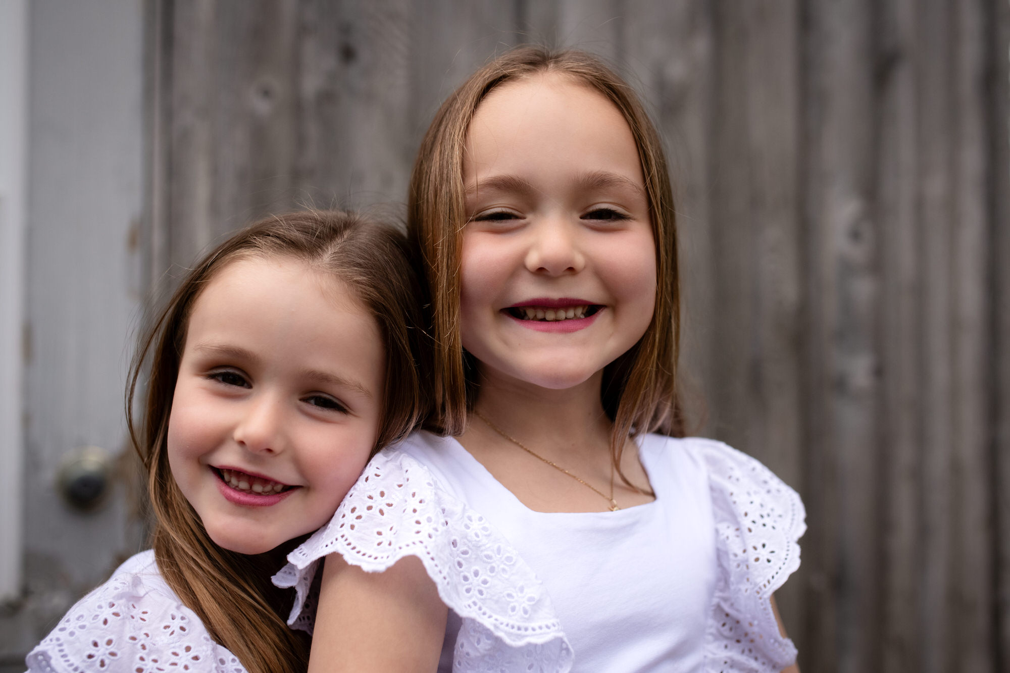 Photo portrait de deux jeunes soeurs souriant en robe blanche