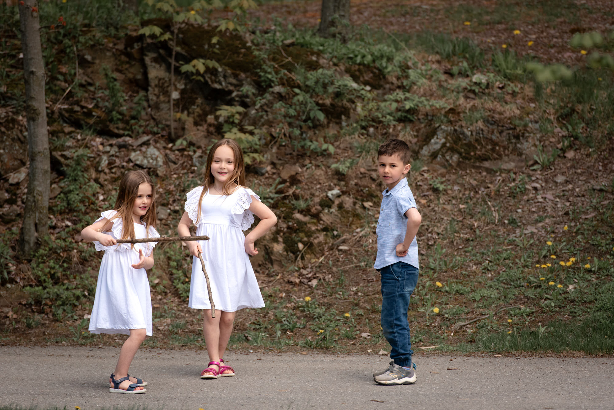 Photo de trois enfants qui s'amusent avec des bâtons à l'extérieur
