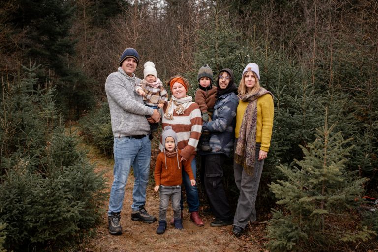 Photo plein pied de deux jeunes famille à l'extérieur avec des sapins en arrière-plan