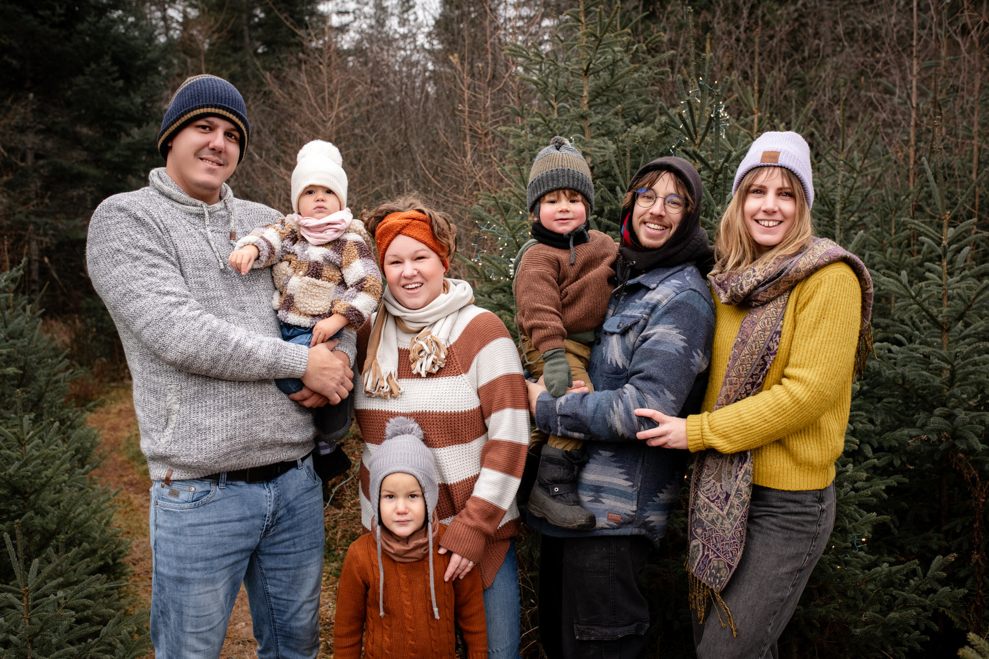 Photo portrait de deux jeunes famille à l'extérieur avec des sapins en arrière-plan