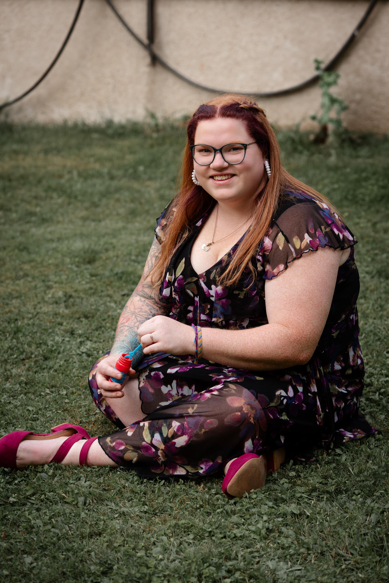 Dame en robe assise par terre avec un objet pour faire des bulles de savon