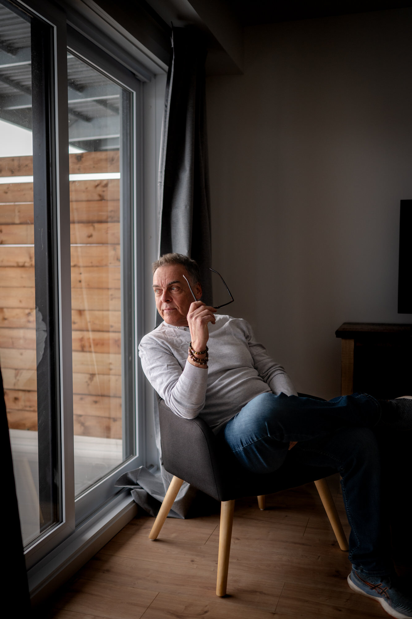 Photo d'un homme qui regarde à l'extérieur avec des lunettes dans les mains