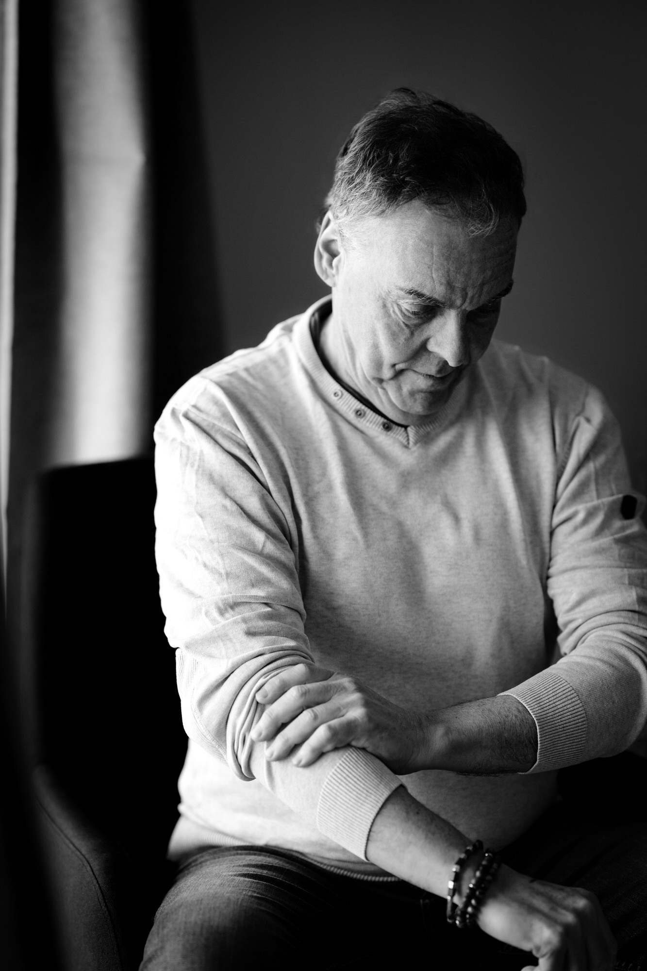 Photo portrait noir et blanc d'un homme pensif qui remonte ses manches