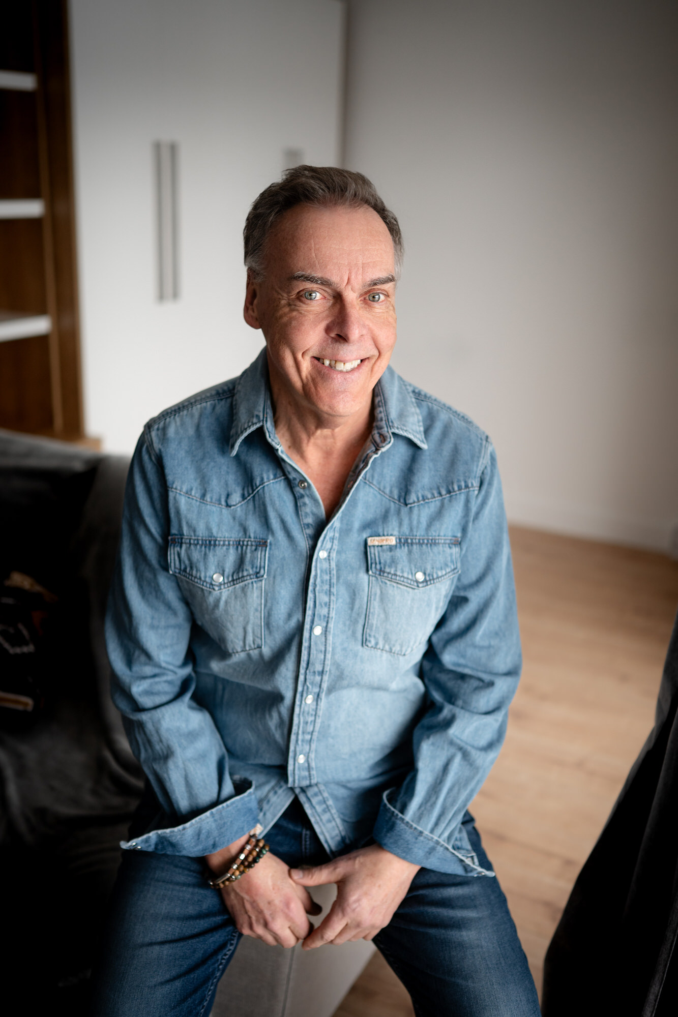 Photo d'un homme souriant assis tout en jeans