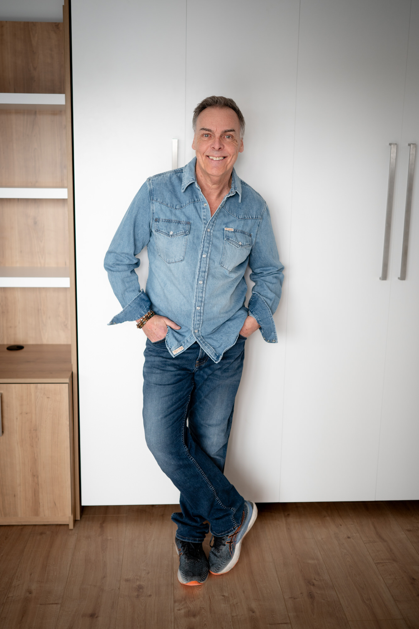 Photo portrait plein pied en jeans les jambes croisées