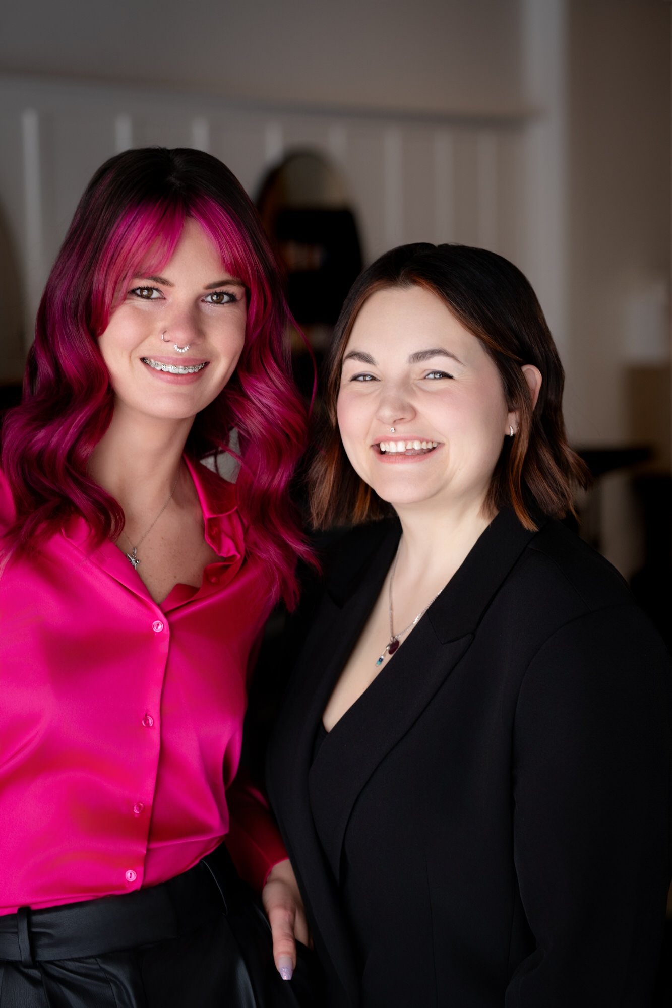 Photo deux jeunes coiffeuses souriantes avec cheimise rose fushia