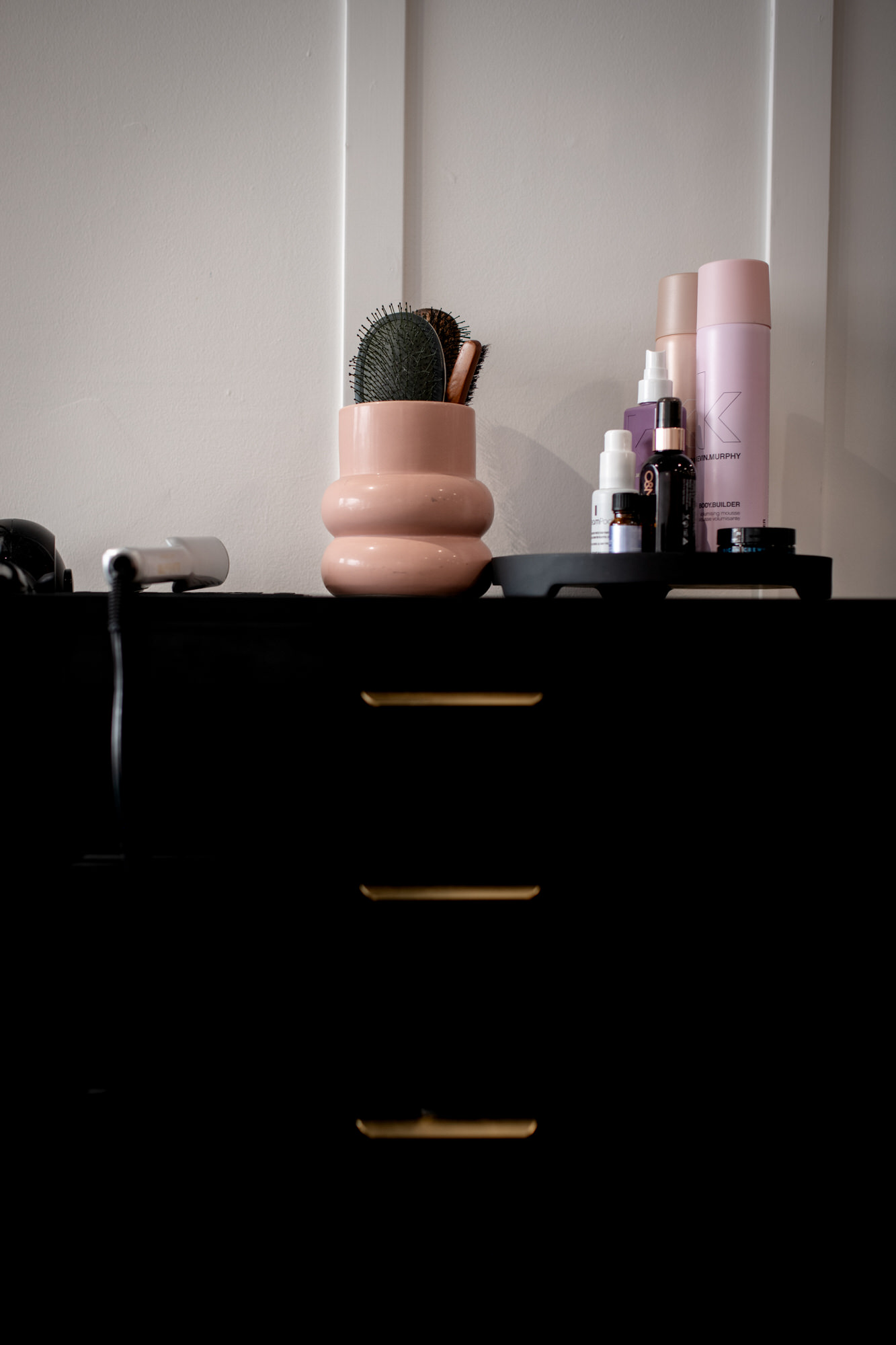 Photo d'un meuble noir avec accessoires coiffants